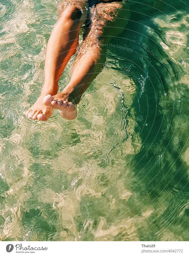 Happy girl have swimming and having fun in sea ocean water. Close up bare legs. People in water sport, extreme activity on summer beach vacation. Watersport background