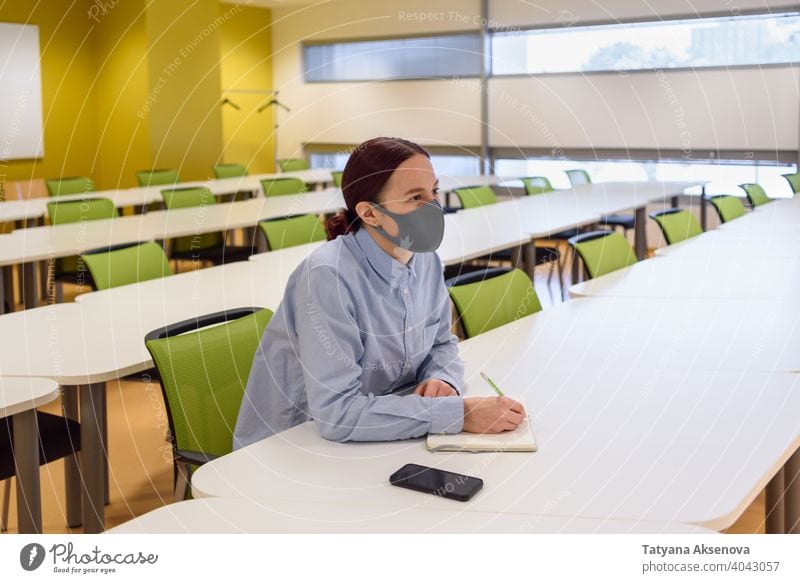 Woman in face mask in empty classroom student education learning school studying woman back to school university new normal person indoor female sitting college