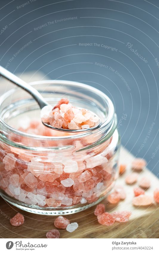 Pink Himalayan salt in glass jar. pink himalayan crystal rock spoon therapy table spice mineral food sodium natural background closeup color macro