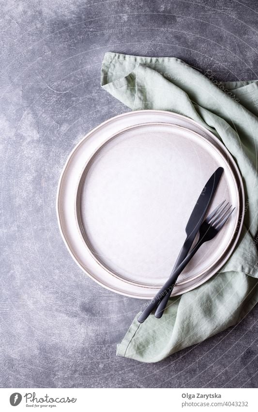 Plates and black cutlery on stone table. plate dish napkin fork knife top view serving flat lay grey linen setting kitchenware empty background utensil