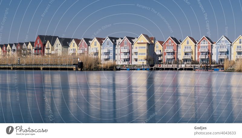 Long exposure of colorful wooden houses (swedish houses) with boat docks at a river Subdued colour Blue Lakeside Wide angle Copy Space bottom Cold