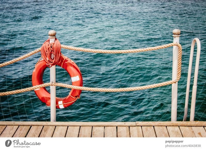 red lifebelt Life belt rescue tyre Lifebelts Navigation Colour photo Deserted Vacation & Travel Tourism Water Exterior shot Day Ocean wooden walkway Footbridge