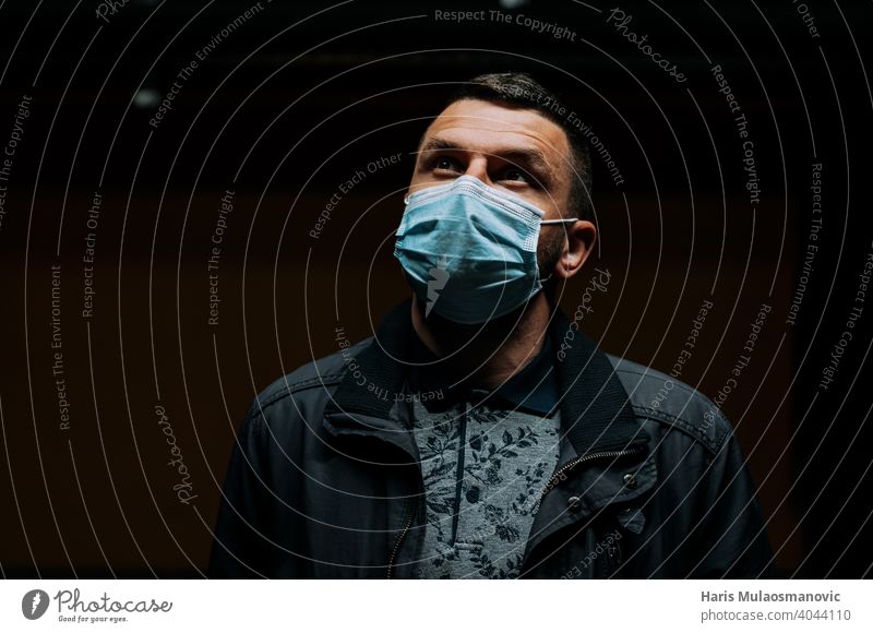 Portrait of man wearing a face mask and looking up on dark black background 19 adult apocalyptic breathe caucasian city concept coronavirus covid 19 covid-19