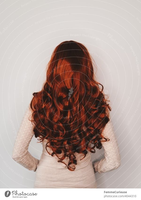 Back view of woman with long red curly hair in skin colored sweater Slim Red skin-coloured Curly Feminine Groomed Glittering Hair and hairstyles Woman