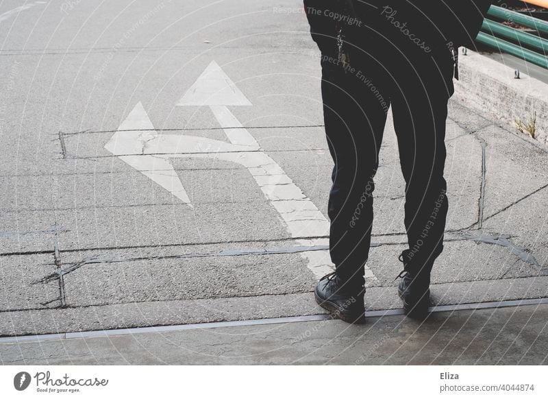 A person stands in front of arrows pointing in different directions. Decision making. Decide Arrow Direction Future decision making off Orientation Road marking