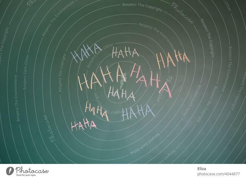 Haha written in several colors on a blackboard. concept laugh, funny and bullying. Laughter harassment Funny josh sb. wittily variegated mob Joke Word authored
