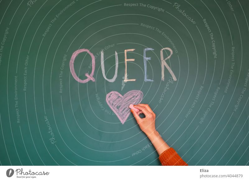 The word Queer is written in colourful letters on a blackboard. One hand draws a heart to it. queer variegated LGBTQ Tolerant Heart Love variety Equality Pride