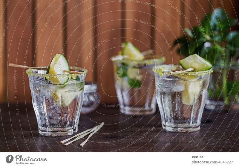 Three glasses of iced flavored water with pineapple, cucumber, peppermint and yellow sugar rim are ready to enjoy Beverage Pineapple Cold drink Water Glasses