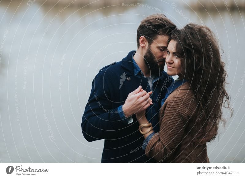 Young couple hugging waist and girl showing thumbs up Stock Photo