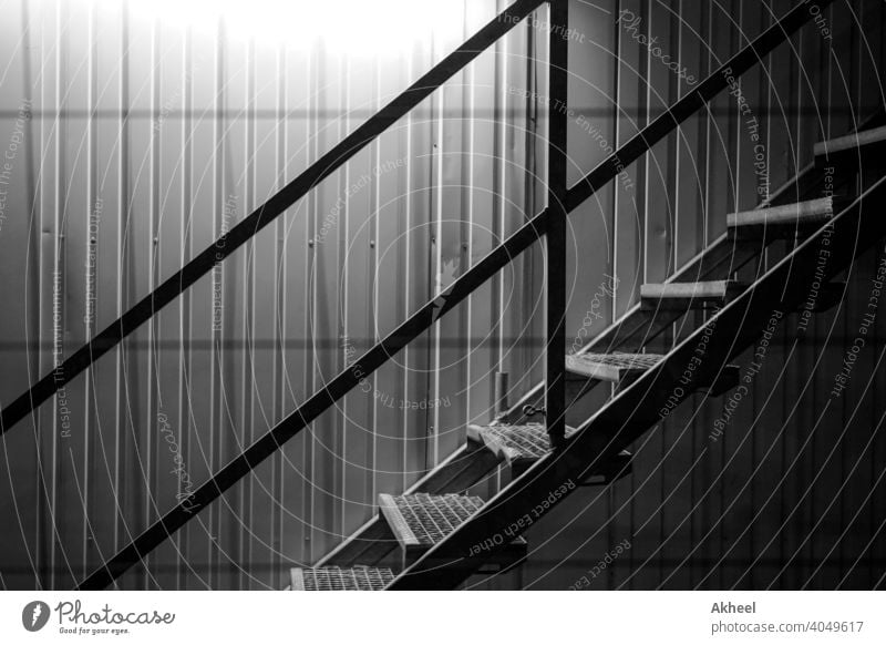 Staircase with lit background in a construction site. shipping container with stairs. abstract architectural architecture black and white building city