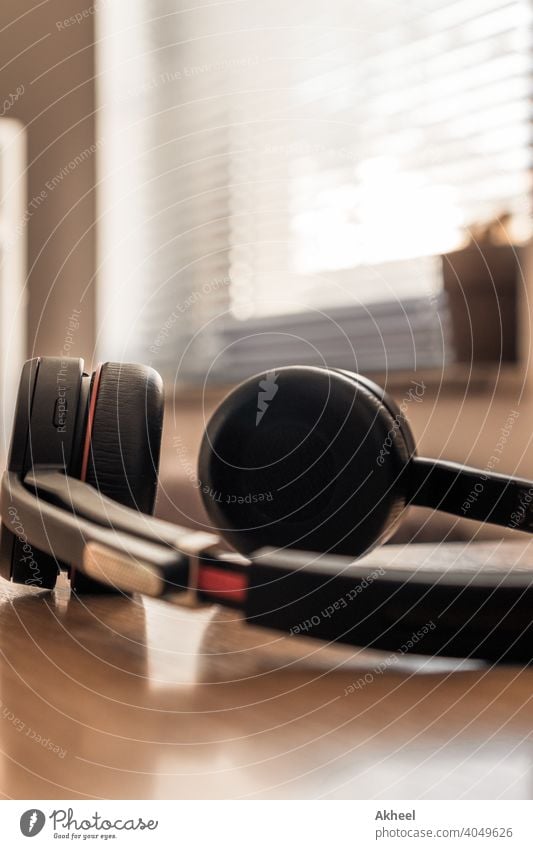 Headphones with mic resting on the table, enjoying summer day without work agenda audio background black blur business chair chairman closeup company concept