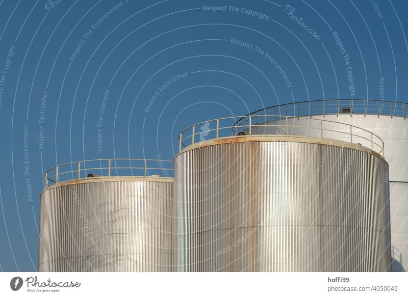 Oil tanks in harbour in front of blue sky Tank Energy industry Gas tank Gasometer Industrial plant Storage Raw materials and fuels Technology Industry Supply
