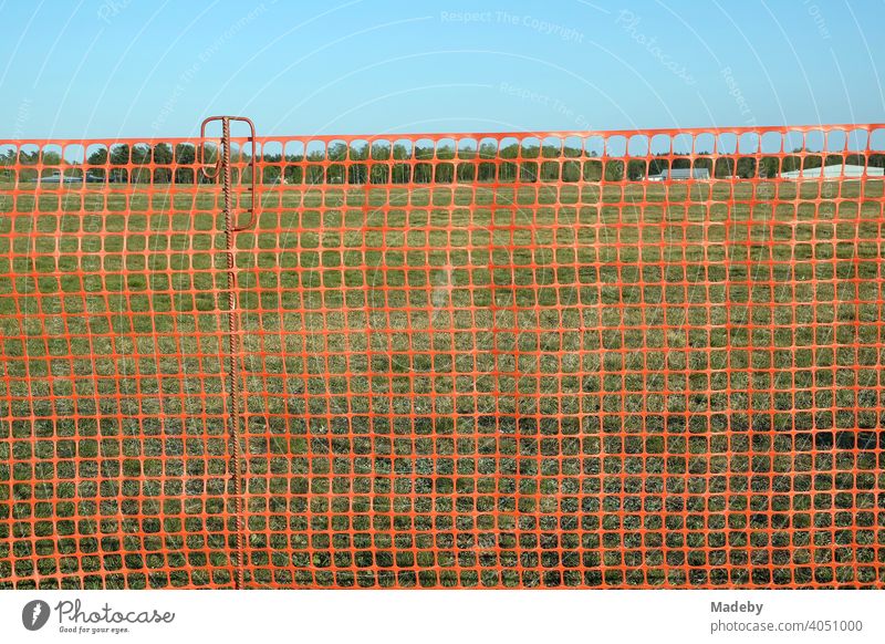 Red net made of plastic as a fence to protect the visitors at the glider airfield Oerlinghausen near Bielefeld in the Teutoburg Forest in East Westphalia-Lippe