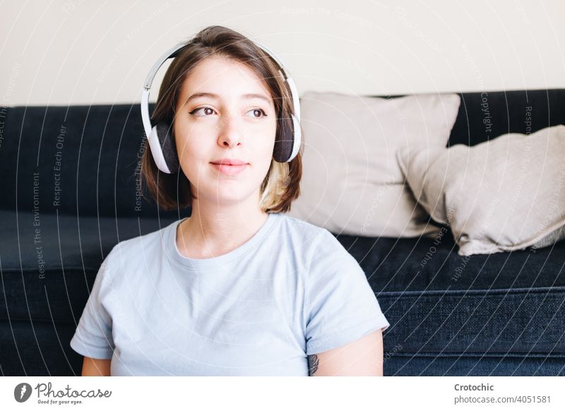 Smiling girl looking thoughtful while listening to music person woman female teenage pensive smile young happy joy smiling caucasian indoor one pretty