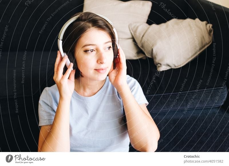 Girl with headphones at home person female woman music happy listening indoors wireless computer laptop young relaxing student enjoying relaxation smile