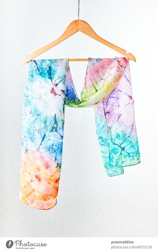 Silk colourful hand painted tied scarf put on white background. Woman fashion, tying a scarf, wearing a scarves. Stylish ways to tie and wear scarves shawl