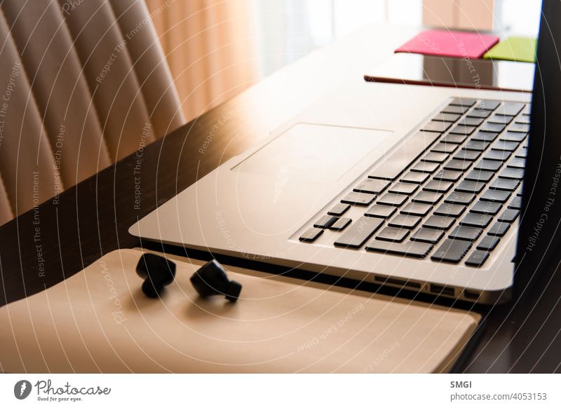 One person's workspace at home: laptop, smartphone and earphones. Conception of teleworking from home. workplace office business computer internet online