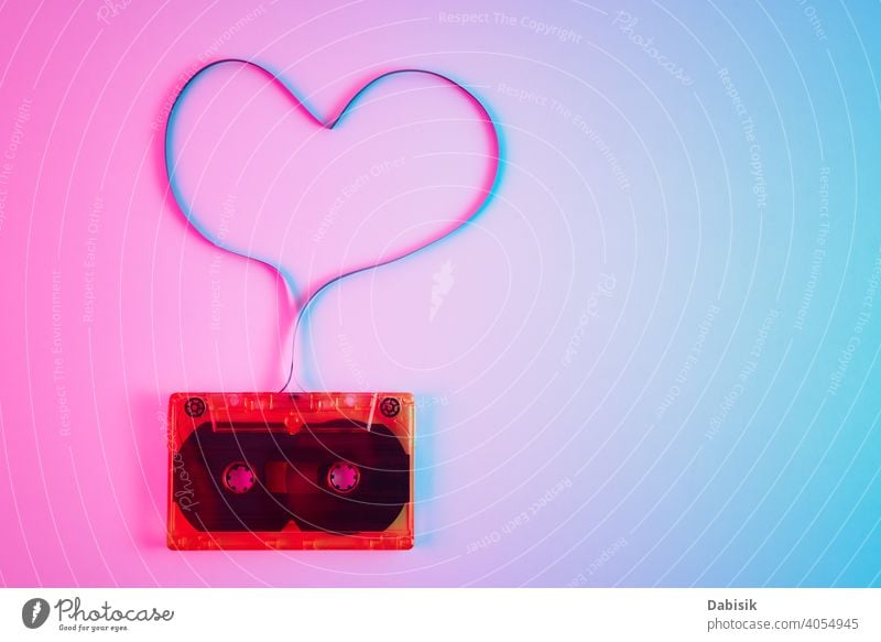 Retro cassette on colorful background with magnetic tape in shape of heart. Love music concept record old stereo vintage retro audio sound media style casette
