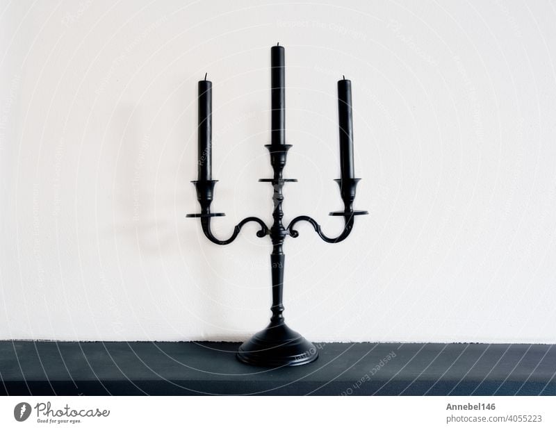 Old vintage retro black candle holder near white background, copy space retro stylish decoration interior candelabrum metal candlestick antique dark traditional