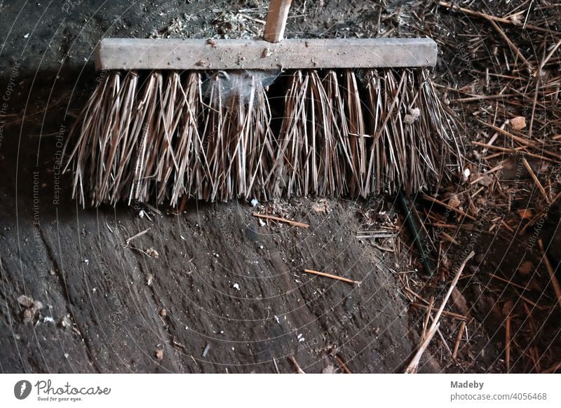 Old broom in a dark dilapidated shed with dry straw on a farm in Rudersau near Rottenbuch in the district of Weilheim-Schongau in the Allgäu in Upper Bavaria