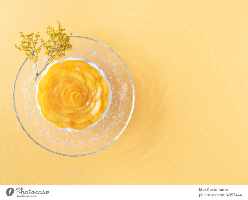 Three milks dessert decorated with peaches on yellow background. Copy space. Top view. creamy sweet fresh jelly fruits panna cotta recipe Colombia