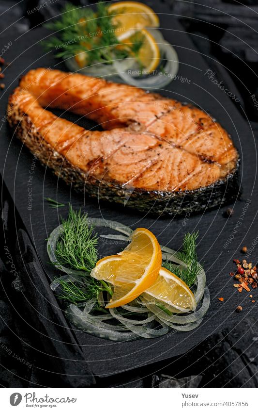 Vertical shot appetizing grilled salmon steak on a black ceramic board. Sea fish. Natural food. steaks background sea natural meal cooked dinner healthy fillet