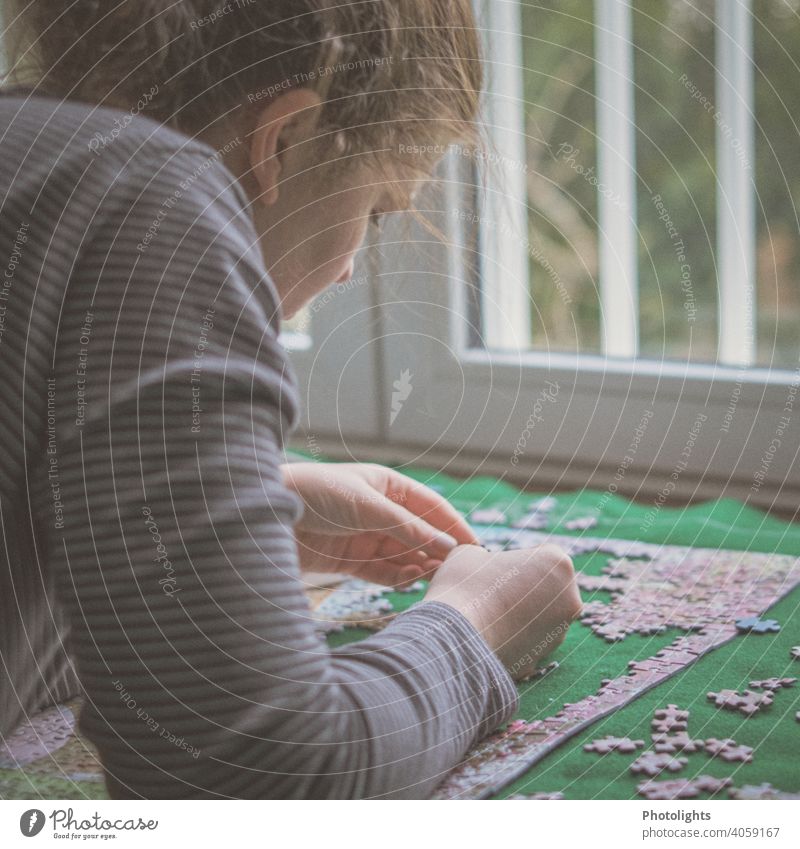 Young woman looking at a puzzle piece Puzzle Woman Colour photo Part Leisure and hobbies Playing Multicoloured Toys Interior shot Search Problem solving