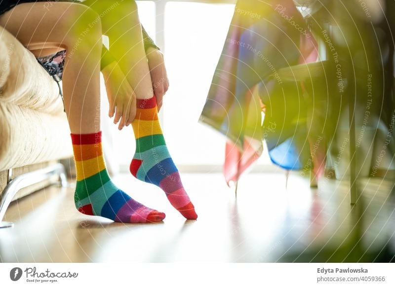 Close-up of a person putting on rainbow socks lgbtq rainbow flag real people pride legs non-binary gender fluid gender fluidity equality homosexual lesbian man