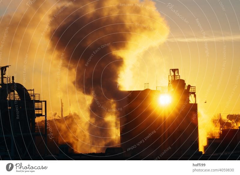 Sunrise, sunset with emissions from an industrial plant CO2 emission Fine particles Carbon dioxide Environmental pollution Steam Chemical Industry Chimney Roof