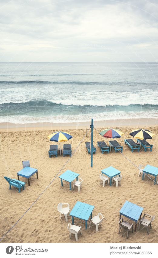 Aerial view of an empty tropical beach with umbrellas, sunbeds, tables and chairs, color toning applied, Sri Lanka. aerial resort vacation tourism season