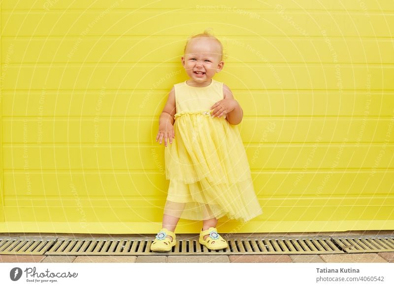 Adorable Little girl smiling on yellow background. kid fun childhood cute happy little todler cheerful smile portrait expression adorable young joy happiness