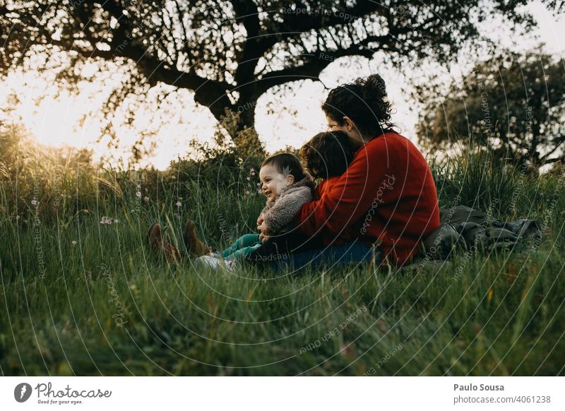 Mother hugging two children outdoors motherhood Mother's Day Motherly love Caucasian Family & Relations family Love Together togetherness care people Lifestyle