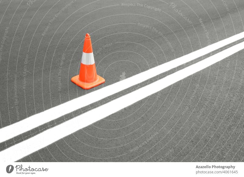 Red road cone on asphalt road with newly painted white lines abstract asphalt pavement asphalt texture background black boundary business car caution color
