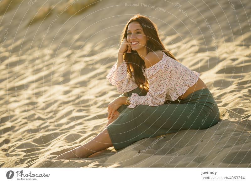 Smiling woman sitting on the sand of the beach smile smiling adult person vacation caucasian female lady girl holiday relax outside young travel summer outdoors