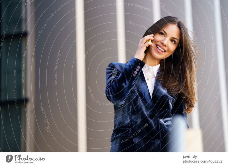 Business woman wearing blue suit using smartphone in an office building. businesswoman girl person device lifestyle female urban background lady elegant outside