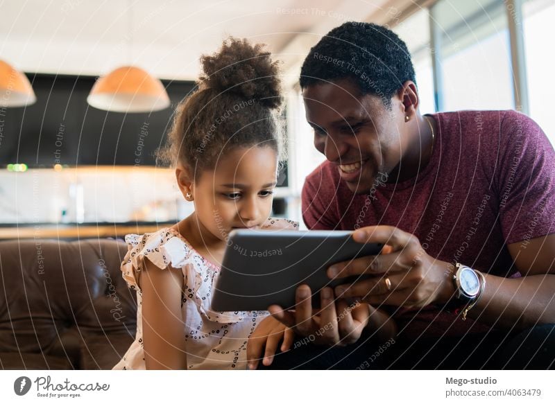 Father and daughter using digital tablet at home. father monoparental play lifestyle family single parent indoor activity parenting relationship daddy cute