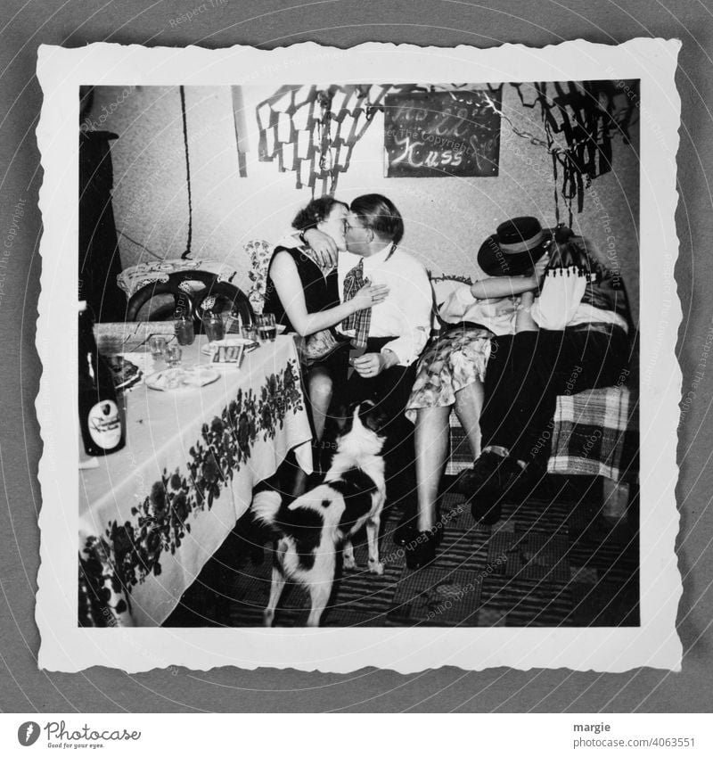 Text on a blackboard: From 10 pm kiss free! Two couples kissing in an analog photo. A dog is watching! Photography Analog Nostalgia family album Take a photo