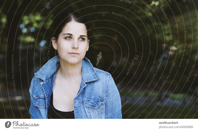 dreamy young woman outdoors gazing into distance - a Royalty Free Stock ...