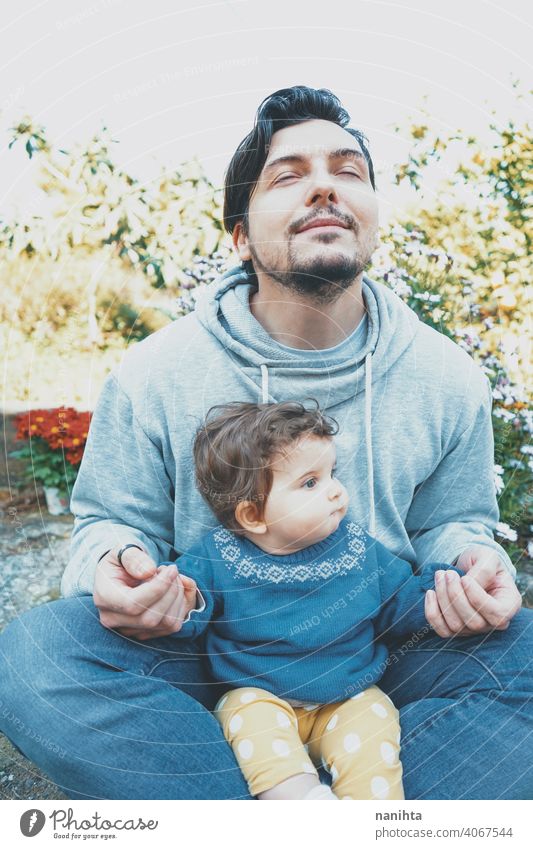 Young dad enjoying a sunny day with his baby in the garden father family love happiness yoga meditation breathing exercises care caring parenting lovely cute