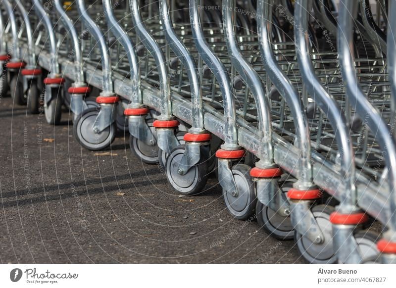 Shopping carts arranged in the parking and entrance area of a giant warehouse supermarket, on the outskirts of Zaragoza city, Spain. Aragon day cloudy sun