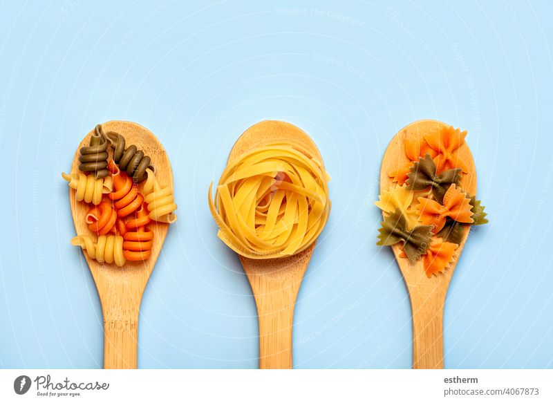 Different raw pasta types in three wooden spoons food eat diet dinner meal meat fresh restaurant menu italy food culinary spagetti tortellini italian cuisine