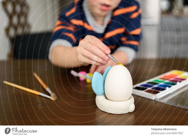 Boy coloring Easter egg easter child decoration dye painting home boy brush easter egg holiday spring indoor tradition fun childhood craft table art caucasian