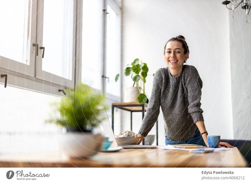 Portrait of a smiling creative woman in a modern loft space millennials student hipster indoors window natural girl adult one attractive successful people