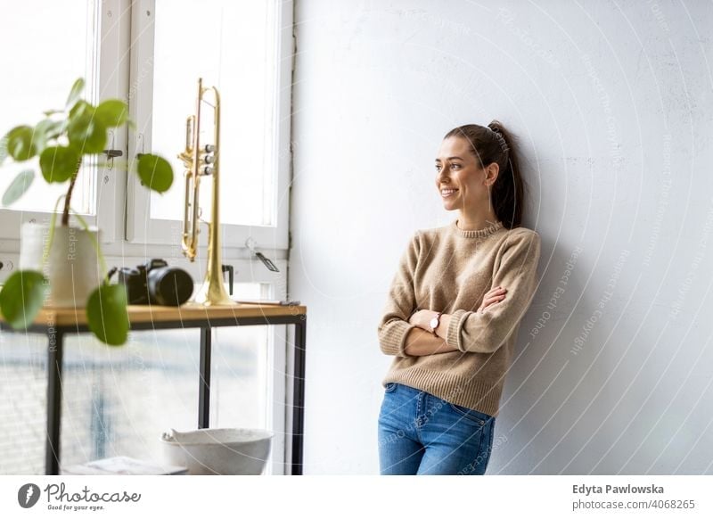 Portrait of a smiling creative woman in a modern loft space millennials student hipster indoors window natural girl adult one attractive successful people