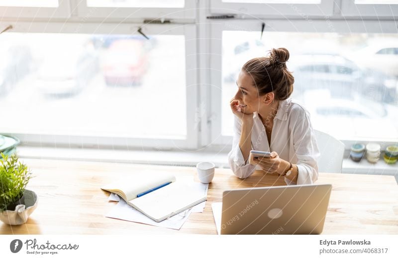 Young woman working in creative start-up company millennials student hipster indoors loft window natural girl adult one attractive successful people confident