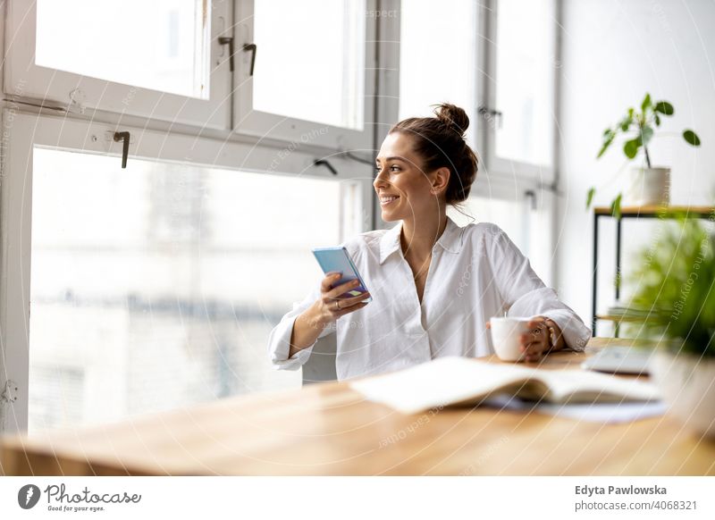 Creative business woman using smartphone in loft office millennials student hipster indoors window natural girl adult attractive successful people confident