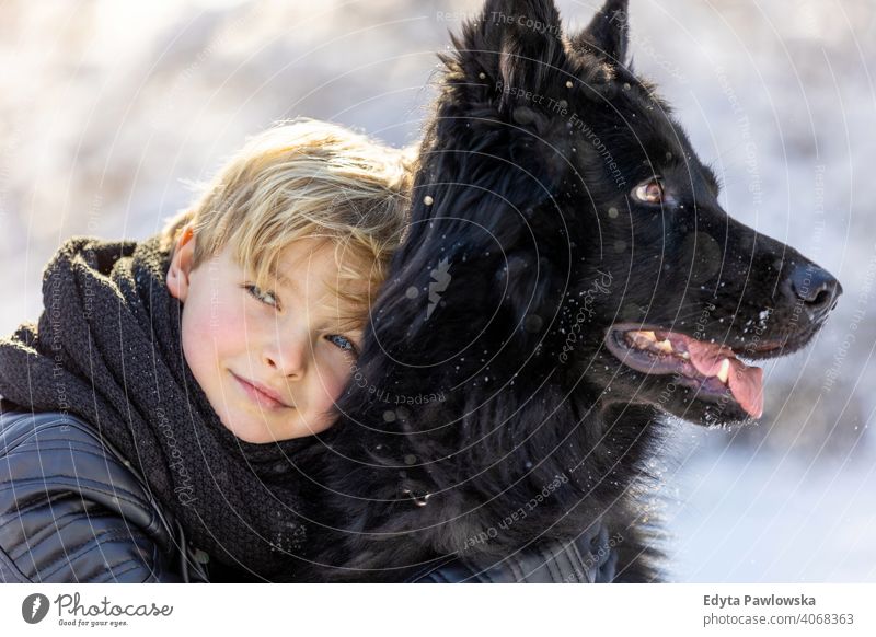 Little boy enjoying winter with his dog black russian activity active adventure day male companion care outdoors forest beauty frost nature tree portrait