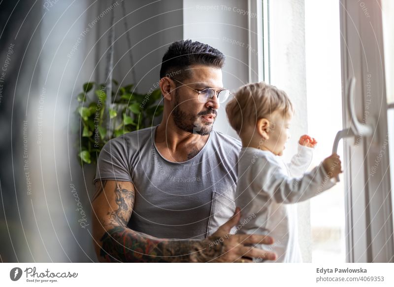 Man with his little son looking through the window at home single parent single dad fathers day fatherhood stay at home dad paternity leave modern manhood