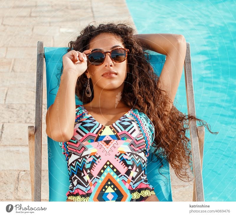 Girl with Dark Hair in Elegant Bikini Relaxing beside Swimming
