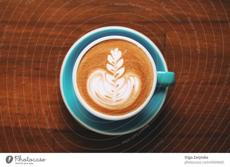 A cup of cappuccino with latte art on wooden table. foam macchiato top view background design cream pattern coffee aroma breakfast brown cafe caffeine drink